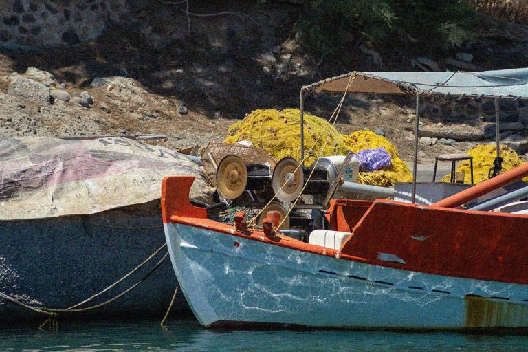 Colorful greek fishing boat and nets in a pier on Santorini, Gre